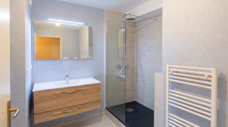 Local technique intérieur en parpaings, avec un chauffe-eau thermodynamique vertical blanc installé contre le mur